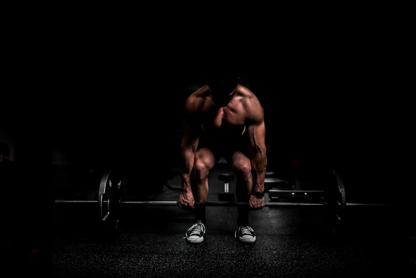 Lifter setting up a deadlift in a dark gym